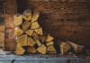 Feuer im Kamin - als oberste Schicht im Kamin kommt über das Anmachholz eine dickere Schicht aus Scheiten von Brennholz.