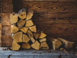 Feuer im Kamin - als oberste Schicht im Kamin kommt über das Anmachholz eine dickere Schicht aus Scheiten von Brennholz.