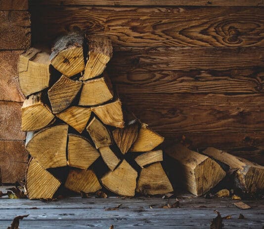 Feuer im Kamin - als oberste Schicht im Kamin kommt über das Anmachholz eine dickere Schicht aus Scheiten von Brennholz.