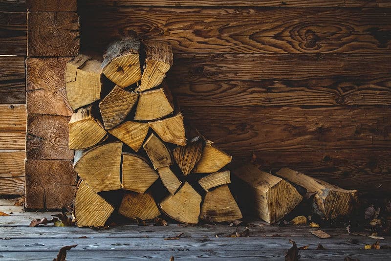 Feuer im Kamin - als oberste Schicht im Kamin kommt  über das Anmachholz eine dickere Schicht  aus Scheiten von Brennholz. 